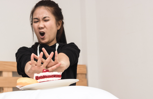中国で女性が顔の前にケーキを持っている。