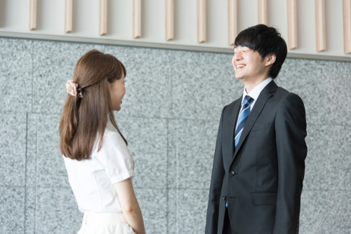 アジア系の若い男性と女性が隣り合って立っています。