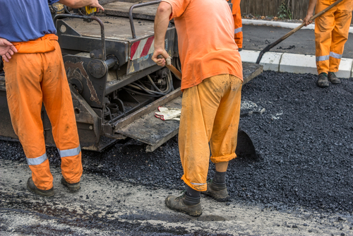 道路で作業する男性のグループ。