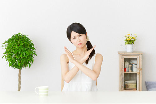 中国の鉢植えの前で身振り手振りをするアジア系の若い女性。