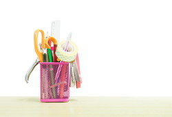 中国の木製テーブルの上にピンクの容器に入った事務用品。