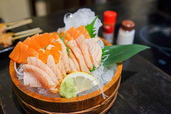 テーブルの上の木製バスケットに入った日本の刺身。