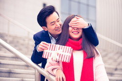 階段でギフトボックスを持った若い中国人カップル。