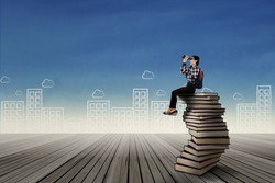 中国で本の山に座って双眼鏡を覗いている男性。