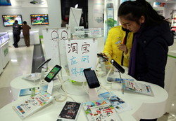 中国の店舗で携帯電話を見ている人々のグループ。