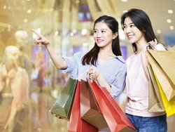 ショッピング モールで買い物袋を保持している中国の 2 人の女性。