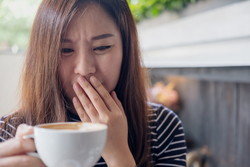 中国から来たアジア系の若い女性がコーヒーを持っています。