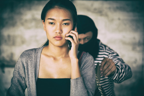 中国で男性の隣で携帯電話で話す女性。