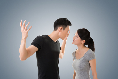 説明：灰色の背景の前で一対の男女が争っています。