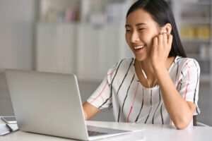 ラップトップで音楽を聴いている若い中国人女性。