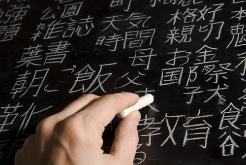 中国の黒板に漢字を書く手。