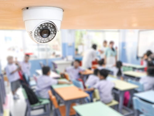 中国の教室には一台の電子ビデオがあり、子供たちは机の上に座っています。