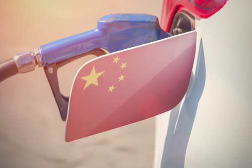 ガソリンポンプに中国国旗を掲げた車が通り過ぎていく。
