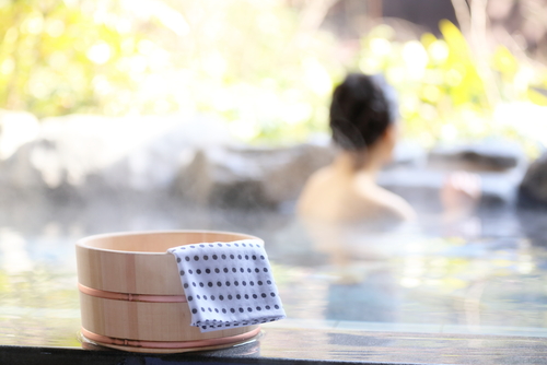 静かな雰囲気に包まれた女性がタオルを持って浴槽に座っています。