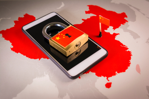 地図の上に中国の国旗と南京錠が表示されたスマートフォン。