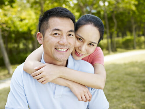 公園で抱き合う中国アジア人の若いカップル。