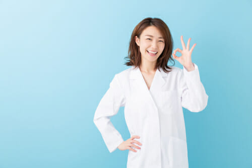 中国でOKサインを示す白衣を着た女性。