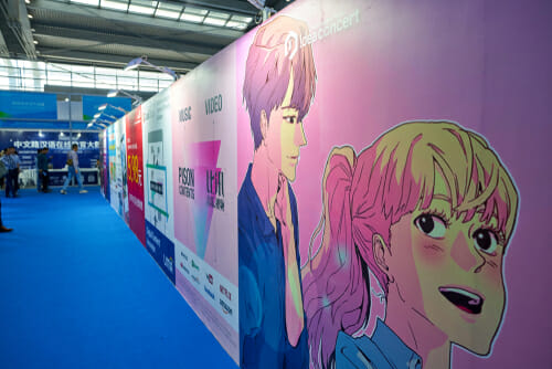 中国から来た女の子と男の子を描いたポスターが貼られた青い壁。