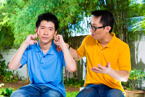 ベンチに座って話し合う二人の中国男性。