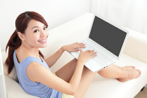 中国でソファに座ってラップトップコンピューターを使用している女性。