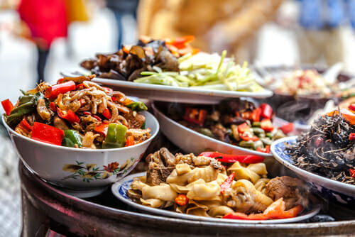 中国の群衆の前のテーブルにたくさんの食べ物が盛られている。