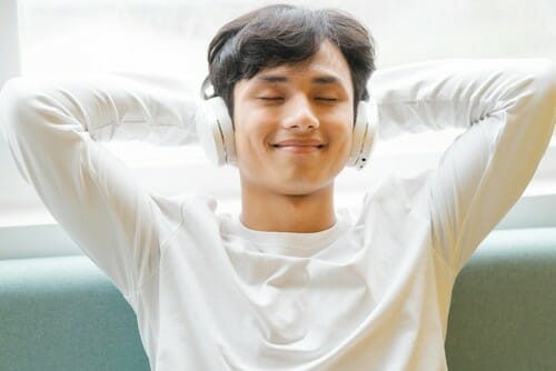ソファでリラックスしながら音楽を聴く中国の若者。