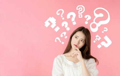 頭の上に疑問符を持つアジアの若い女性。