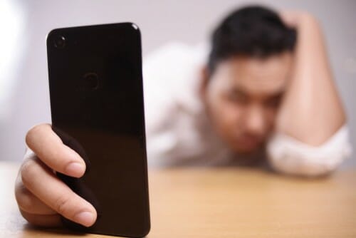 中国から来た男性が電話を手に持っています。