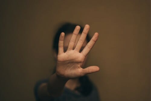 中国で、ぼやけた背景の前で女性が手をかざしている。