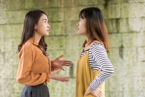 壁の前で話している中国人女性 2 人。