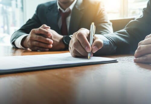 中国のテーブルで文書に署名する2人のビジネスマン。