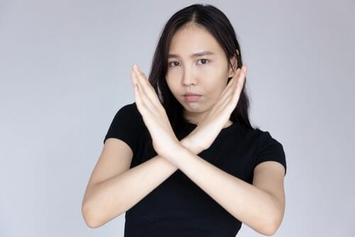 中国で手で一時停止の標識を作るアジアの女性。