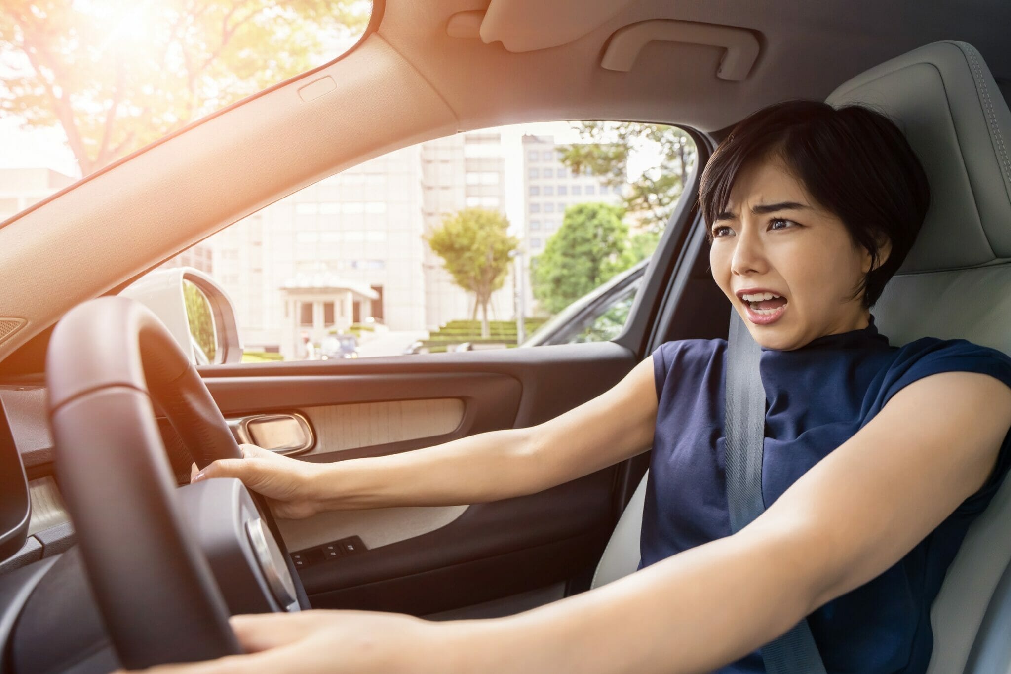 中国でハンドルに手を置いて車を運転する女性。