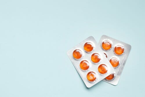 中国の青い背景にオレンジ色の錠剤のパック。