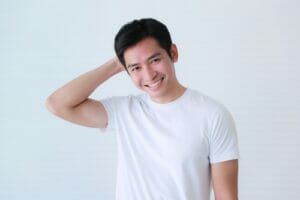 白い背景の前でポーズをとる若い中国男性。
