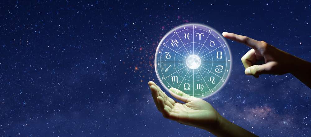 中国で、星空の前で光る星占いを持っている人の手。