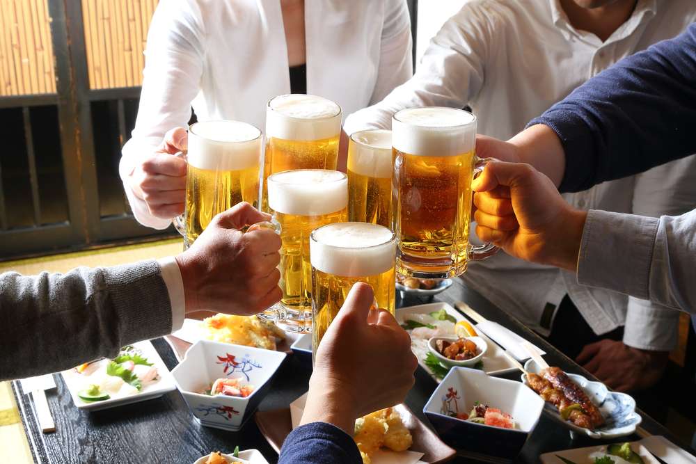 中国のテーブルでビールで乾杯する人々のグループ。