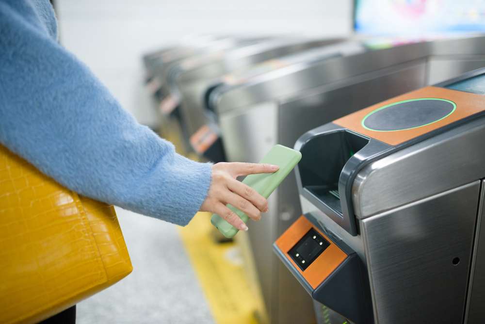中国の地下鉄の駅で女性が券売機を使っている。