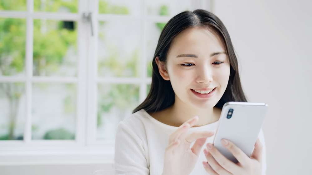 携帯電話を見ている若い中国人女性。