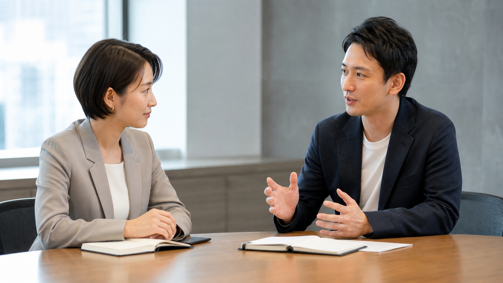 会議室で互いの意見を尊重しながら穏やかに会話する二人の同僚
