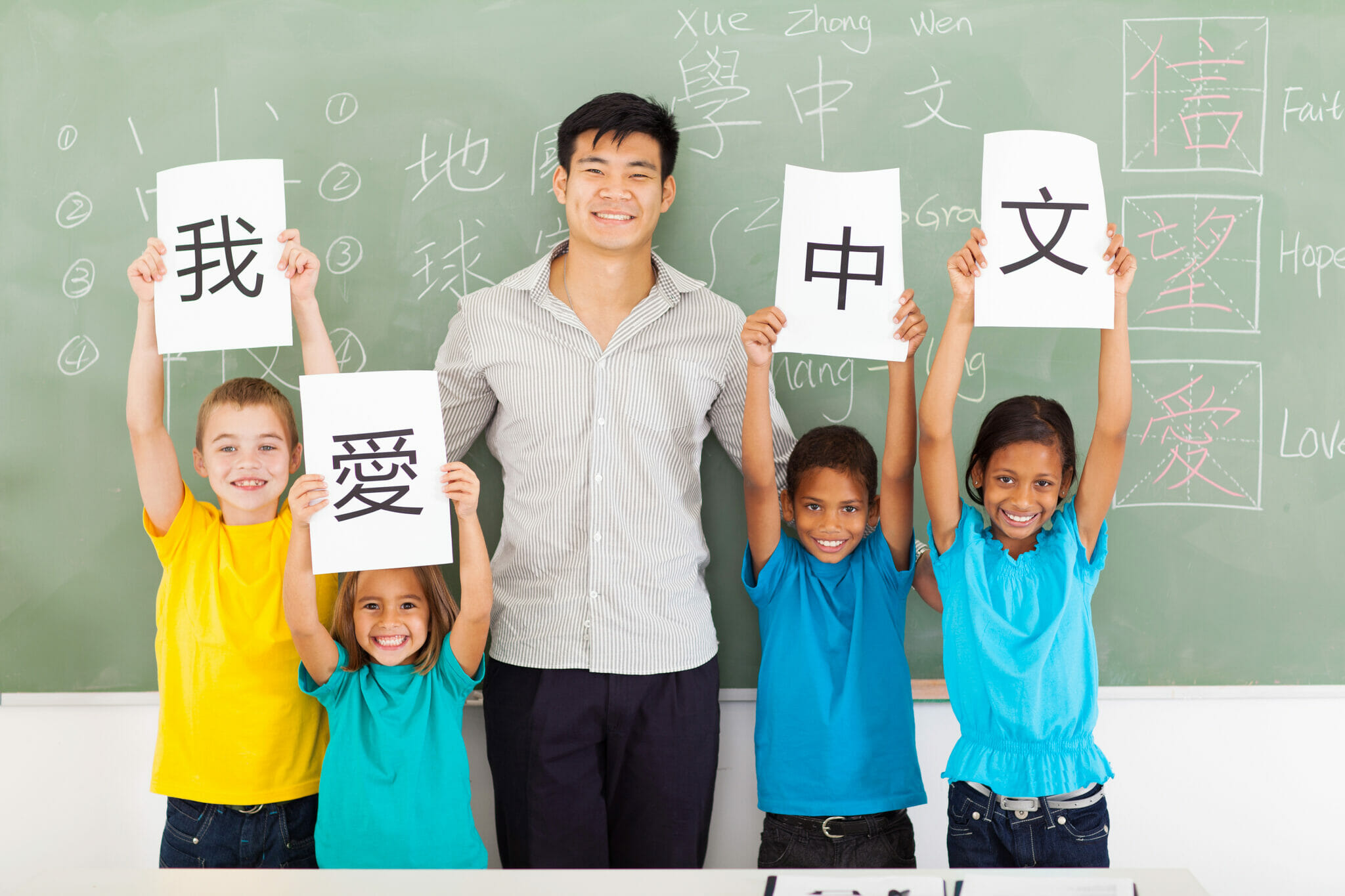 中国の文字が書かれた看板を掲げる子供たち。
