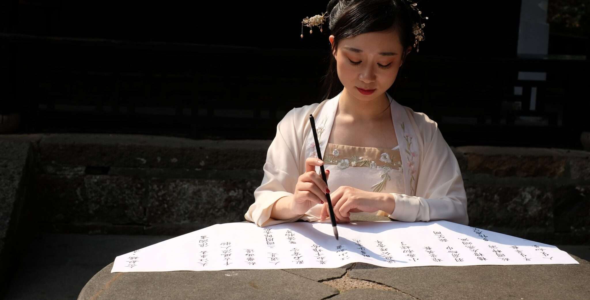 紙に何かを書く中国の女性。