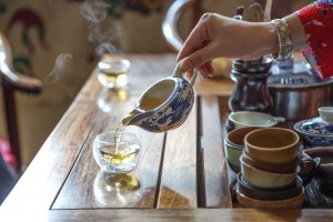 描写: 一人がコップの上でお茶をグラスに注いだ。
关键词：中国
