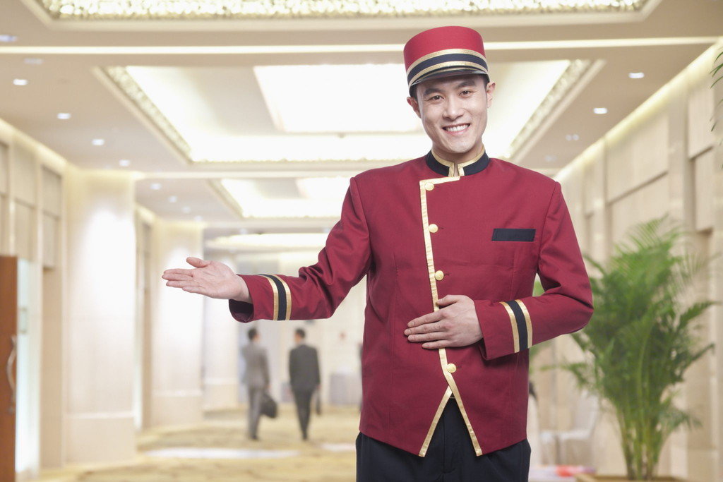 中国の廊下に立つ赤い制服を着た男性。