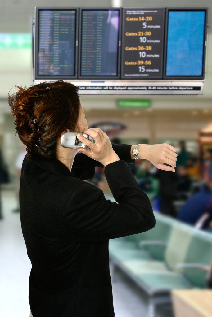 中国の空港で携帯電話で話す女性。
