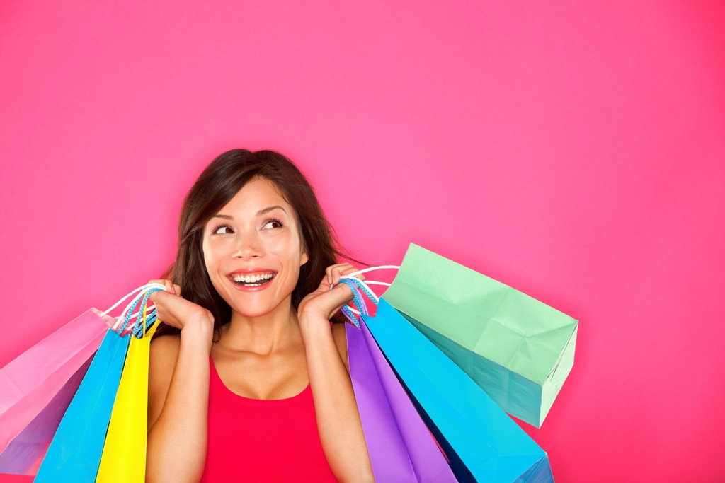 中国のピンクの背景に買い物袋を持つ女性。