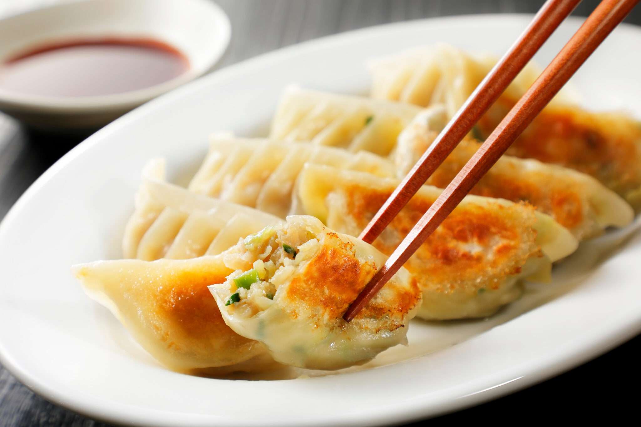 白い皿に箸で餃子。