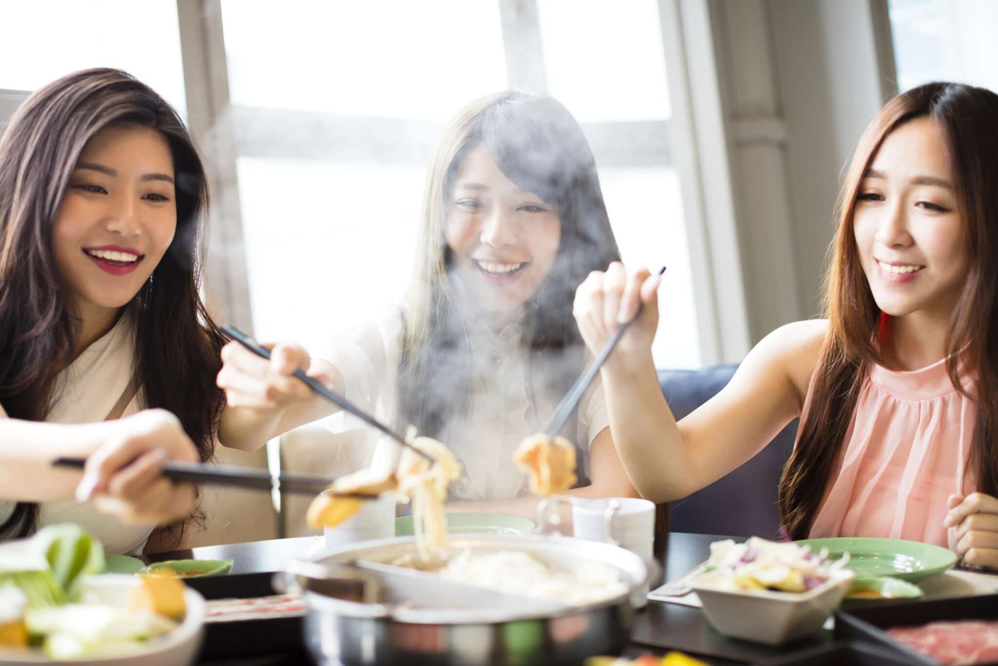 レストランで食事を楽しむ中国の女性 3 人。