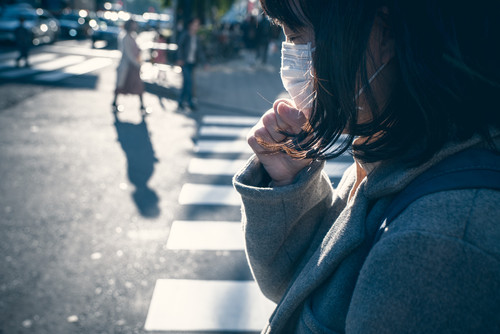路上でフェイスマスクをした女性。