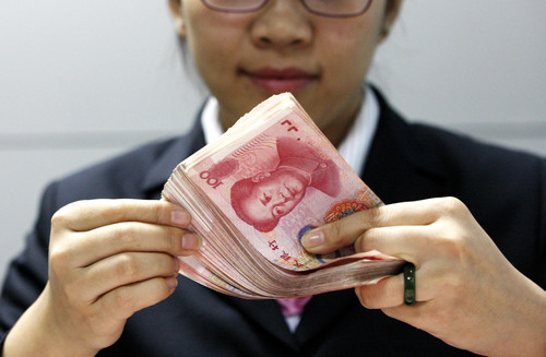 中国の通貨の束を保持している女性。